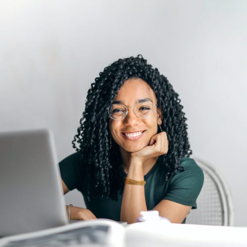 happy-ethnic-woman-sitting-at-table-with-laptop-3769021.jpg